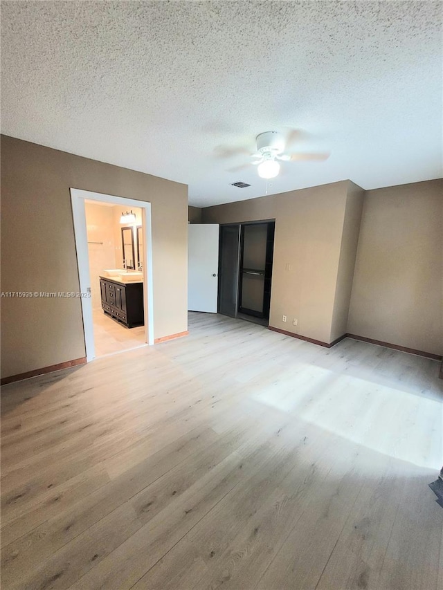 empty room featuring ceiling fan, a textured ceiling, and light hardwood / wood-style flooring