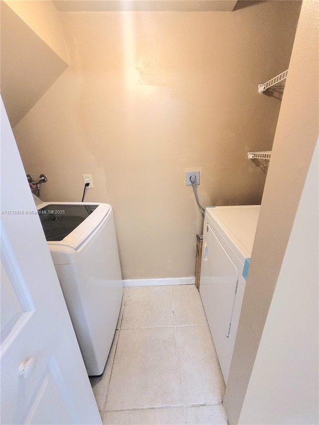 washroom with light tile patterned floors and washing machine and dryer