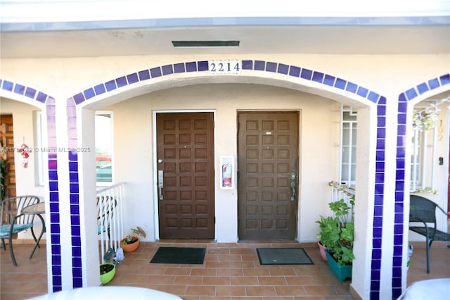 view of exterior entry featuring covered porch