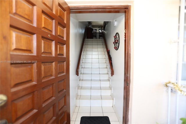 staircase featuring tile patterned flooring