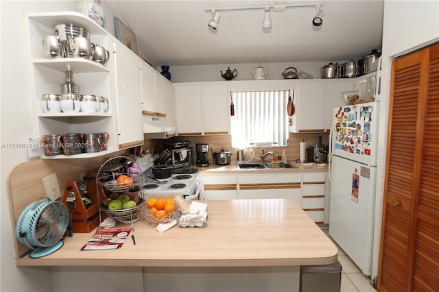 kitchen with white cabinetry, sink, stove, white fridge, and light tile patterned flooring