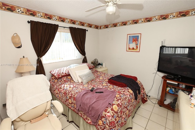 tiled bedroom with ceiling fan and a textured ceiling