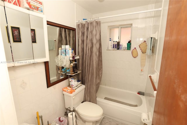 bathroom with toilet, shower / bath combo with shower curtain, and tile walls