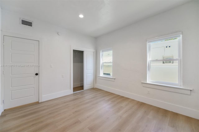 unfurnished bedroom with light wood-type flooring and a closet