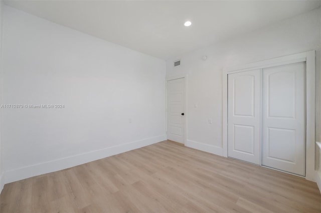 unfurnished bedroom featuring a closet and light wood-type flooring