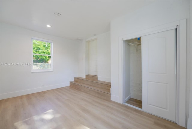 unfurnished bedroom featuring a closet and light hardwood / wood-style flooring