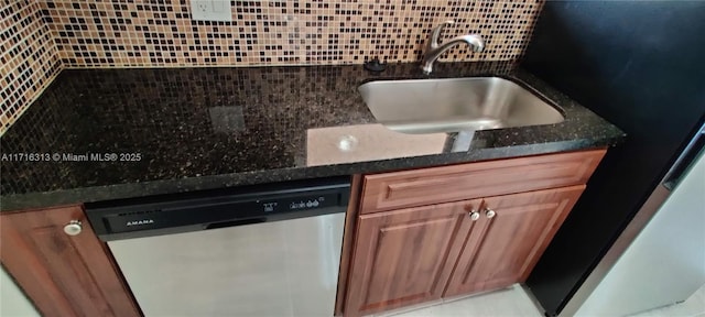 kitchen featuring decorative backsplash, stainless steel appliances, dark stone counters, and sink