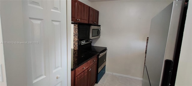 kitchen featuring dark stone countertops, light tile patterned floors, and stainless steel appliances