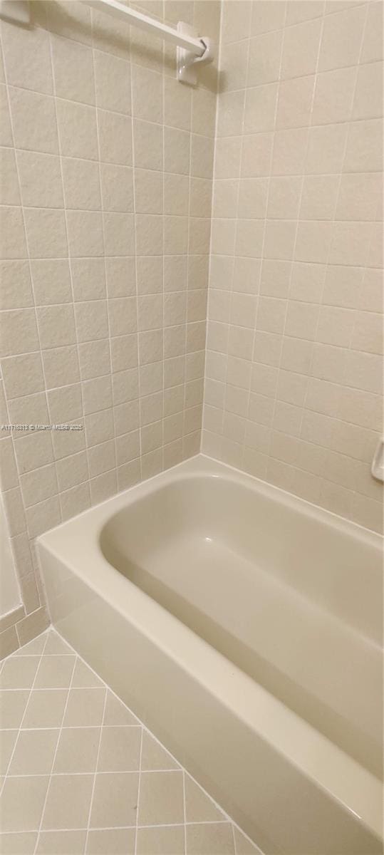 bathroom with tile patterned flooring and shower / bathtub combination