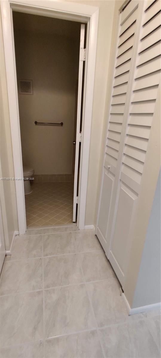 hall featuring light tile patterned flooring