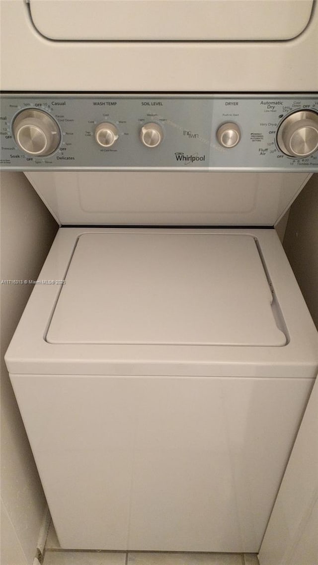 clothes washing area featuring stacked washer and dryer