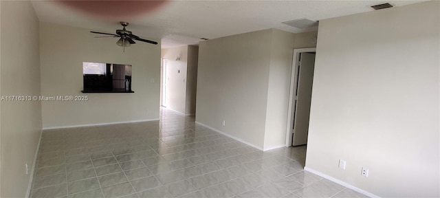 spare room with ceiling fan and light tile patterned floors