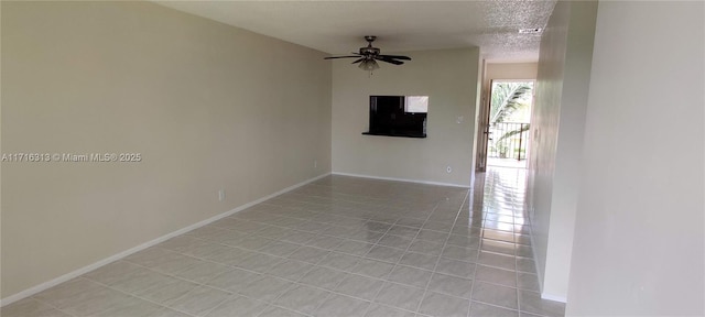 tiled spare room featuring ceiling fan and a textured ceiling