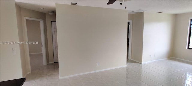 tiled empty room featuring a textured ceiling and ceiling fan