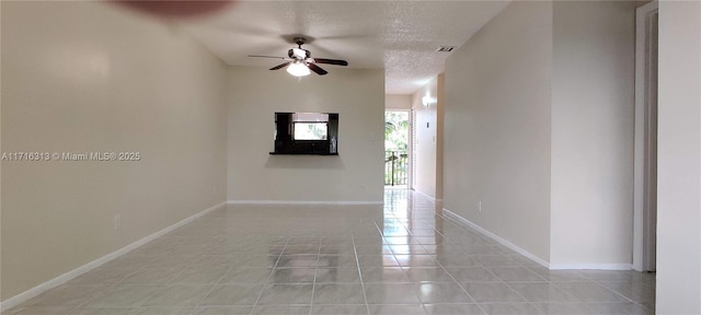 tiled spare room featuring ceiling fan and a textured ceiling