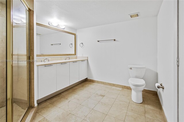 bathroom with toilet, a shower with shower door, and vanity