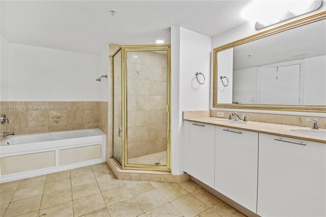 bathroom with vanity, tile patterned floors, independent shower and bath, and a textured ceiling