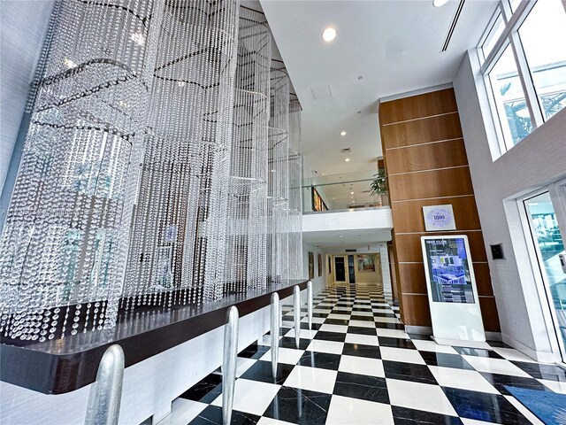 stairs featuring a wall of windows, a wealth of natural light, and an inviting chandelier