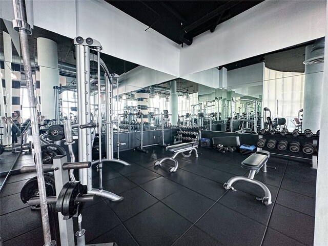 exercise room with a high ceiling and expansive windows