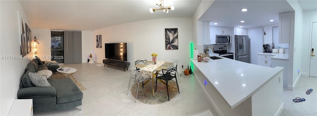 living room featuring sink, lofted ceiling, and a notable chandelier