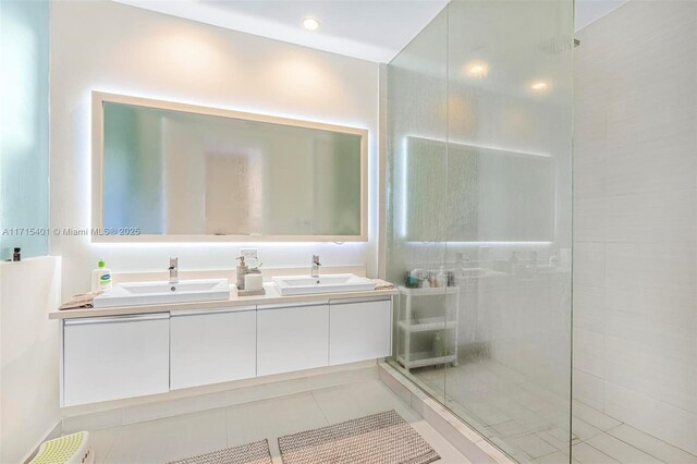 bathroom with tile patterned floors, vanity, and a tile shower