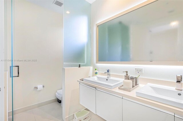 bathroom featuring tile patterned floors, walk in shower, vanity, and toilet