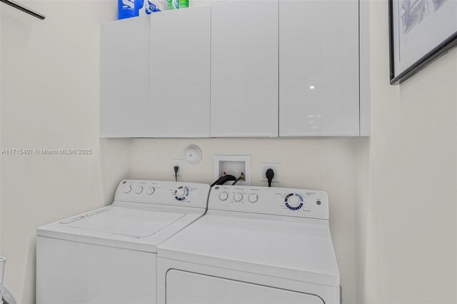 clothes washing area featuring cabinets and washing machine and dryer