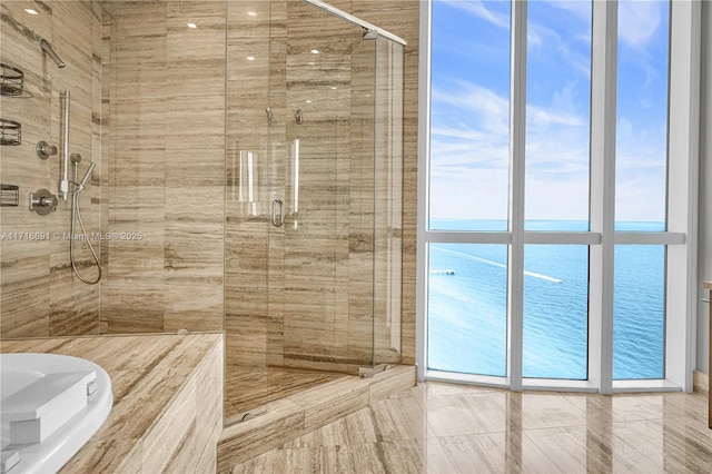 bathroom with an enclosed shower, floor to ceiling windows, and a water view