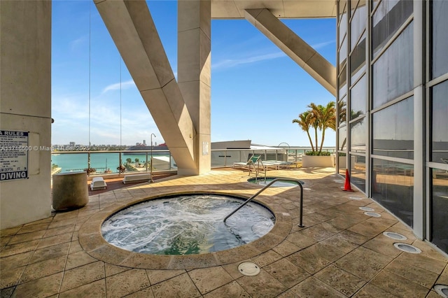 view of patio with a water view and a community hot tub