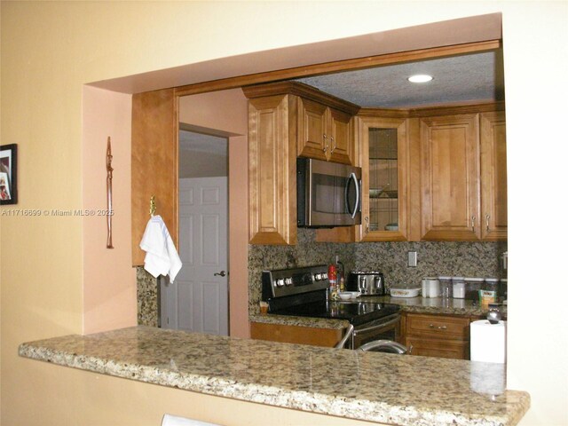 4723 NW 44th St, Tamarac, FL 33319 - kitchen featuring brown cabinets, a notable chandelier, appliances with stainless steel finishes, and tasteful backsplash