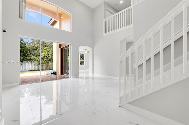 entryway featuring ceiling fan and a high ceiling