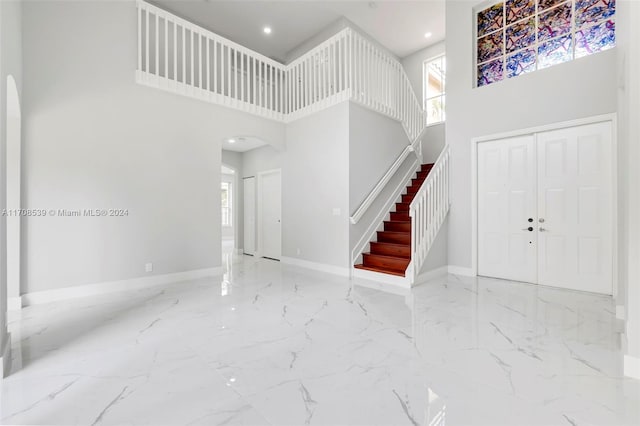 foyer entrance featuring a towering ceiling