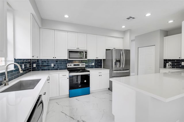 kitchen with decorative backsplash, sink, white cabinets, and appliances with stainless steel finishes