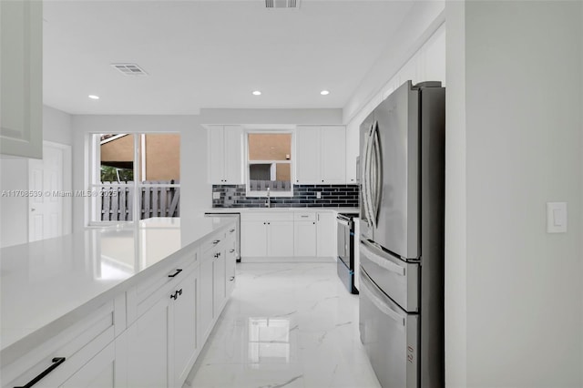 kitchen with white cabinets, appliances with stainless steel finishes, tasteful backsplash, and sink