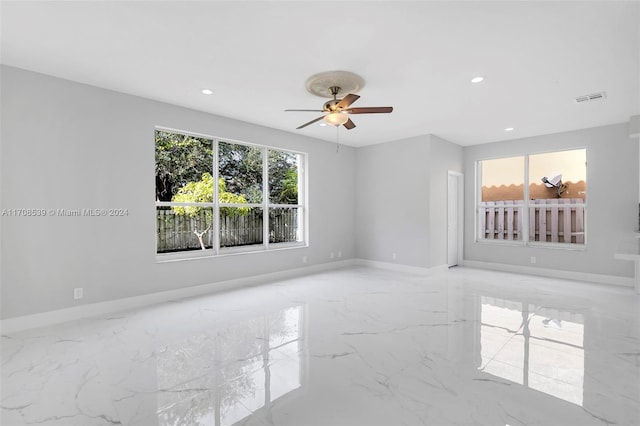 empty room with ceiling fan and a healthy amount of sunlight