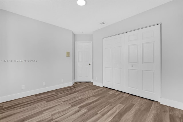 unfurnished bedroom featuring light hardwood / wood-style floors and a closet