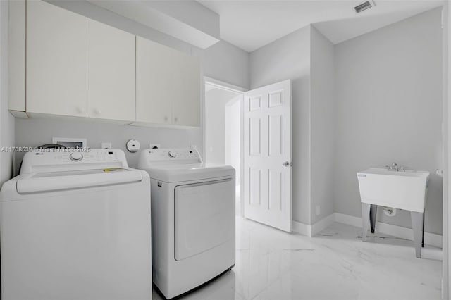 washroom featuring washing machine and clothes dryer and cabinets