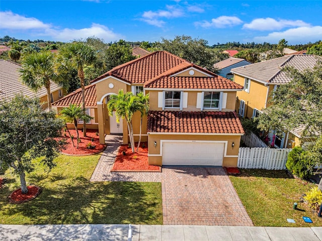 mediterranean / spanish-style house with a garage and a front yard