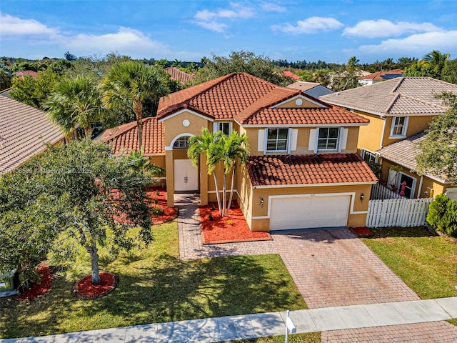 mediterranean / spanish house featuring a garage and a front yard