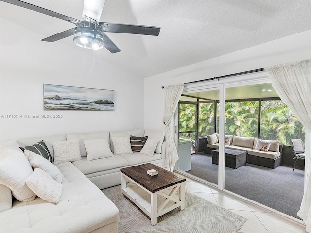 living room with ceiling fan, light tile patterned floors, a textured ceiling, and lofted ceiling