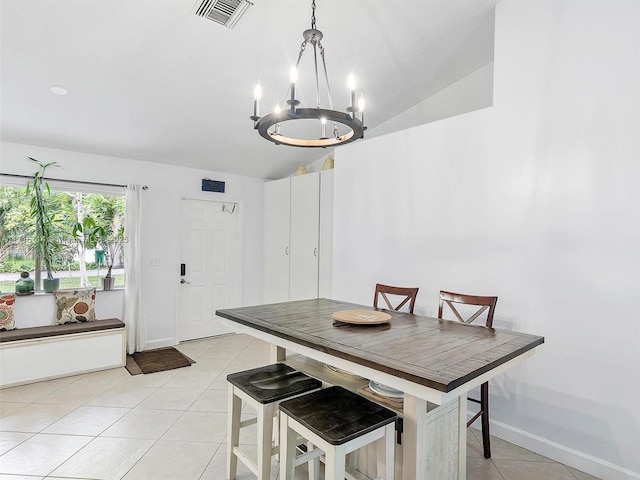 dining room with light tile patterned floors, an inviting chandelier, and vaulted ceiling