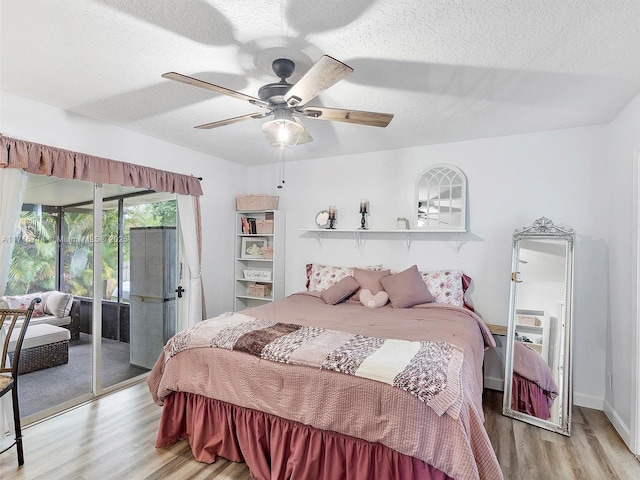 bedroom featuring ceiling fan, light hardwood / wood-style floors, a textured ceiling, and access to outside