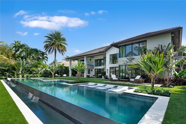 view of swimming pool with a lawn and a jacuzzi