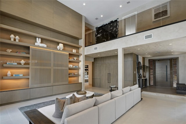 tiled living room with built in shelves and a high ceiling