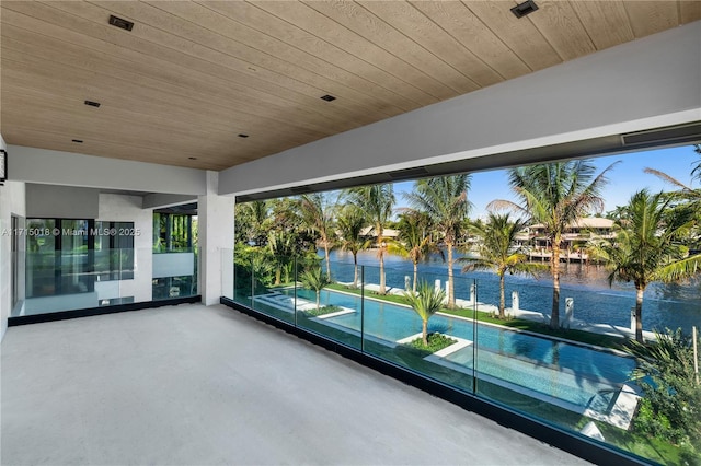 unfurnished sunroom with a water view and wooden ceiling