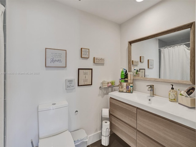 bathroom featuring vanity, toilet, and walk in shower