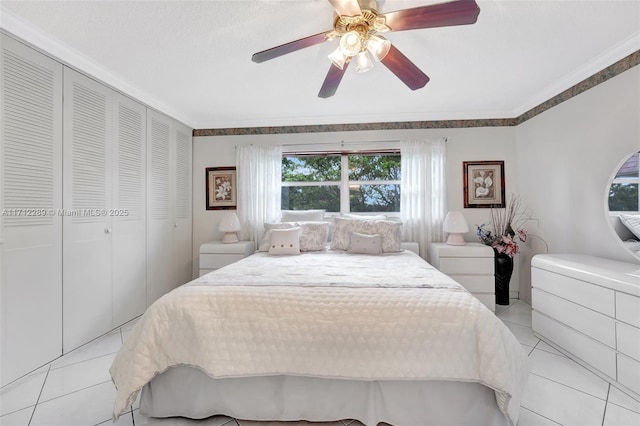 tiled bedroom featuring ceiling fan, crown molding, and a closet