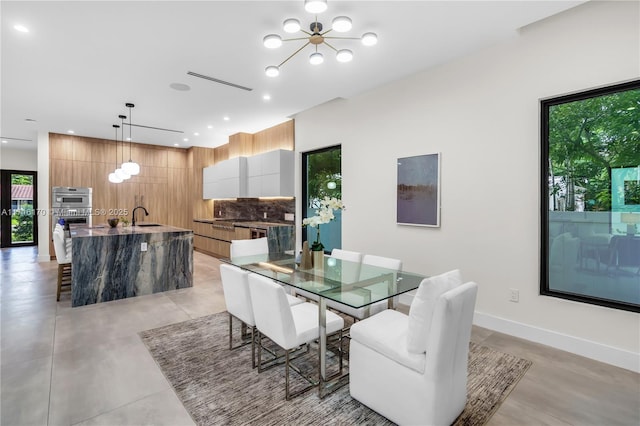 dining room with sink and an inviting chandelier