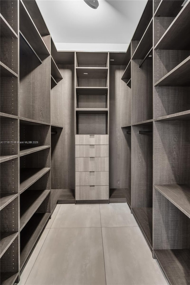 spacious closet with light tile patterned floors