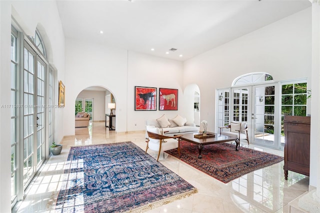 living room featuring a towering ceiling and french doors